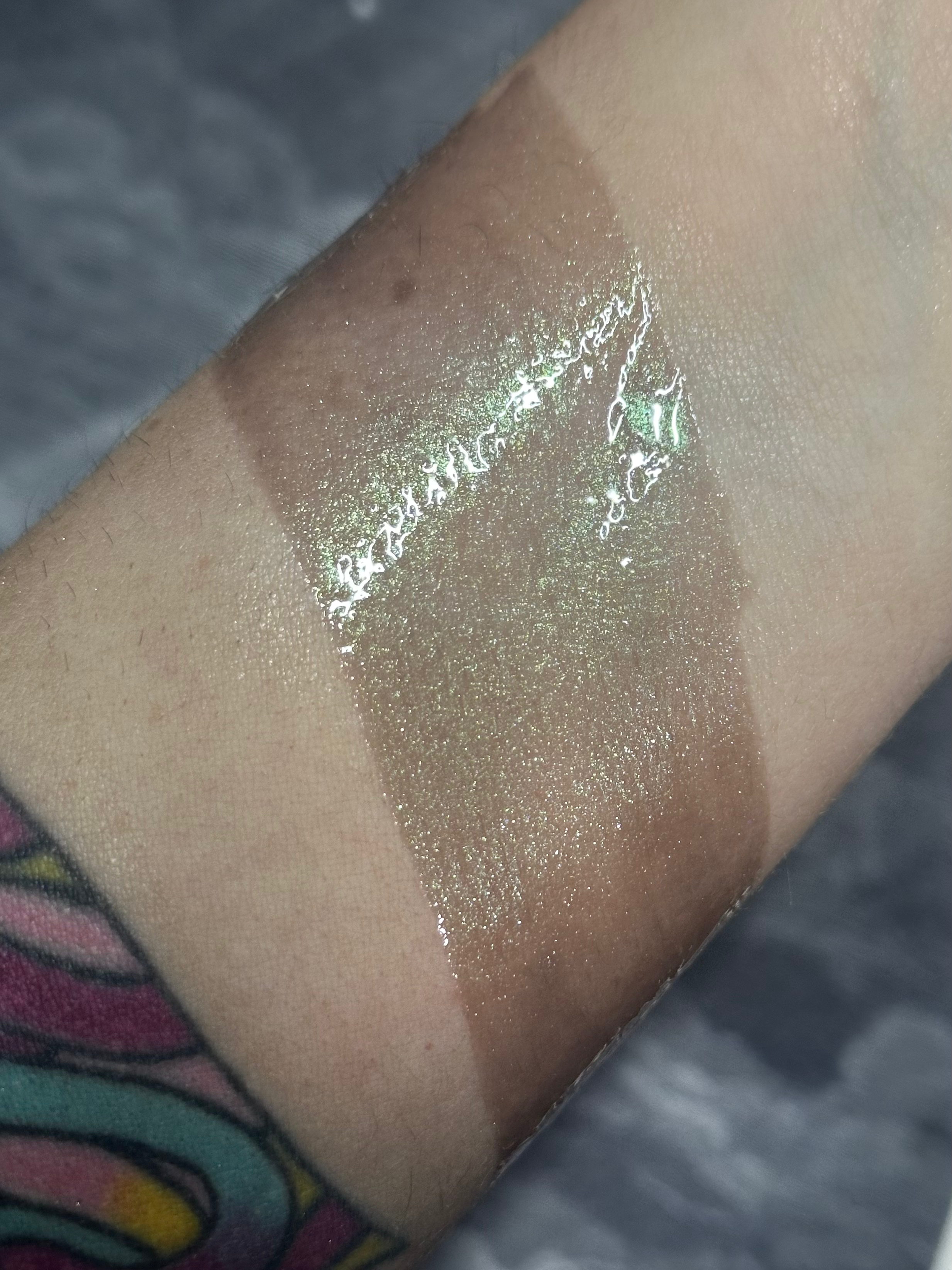 Arm with makeup swatches, Beatrice - Metallic Copper Rusty Gold Pressed Eyeshadow, demonstrating color variations.