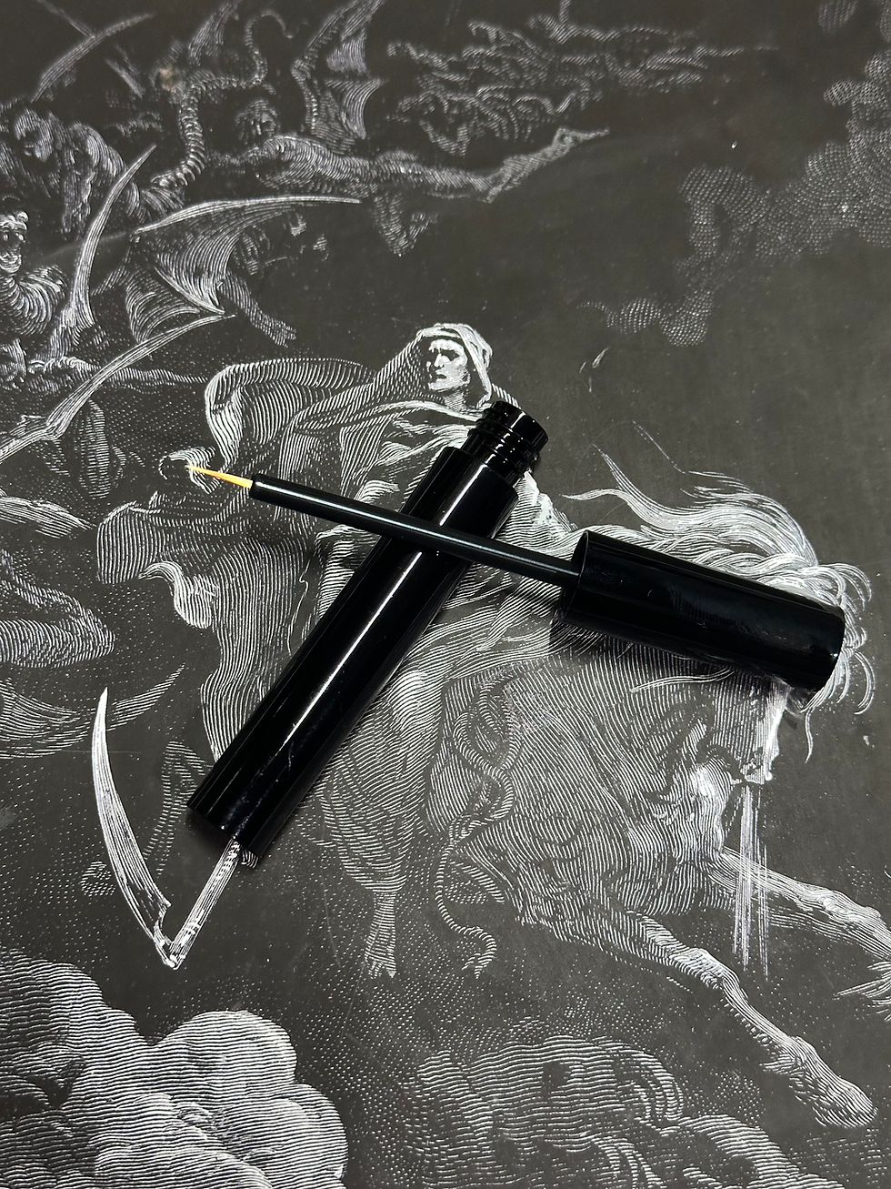 Thumbnail: Black eyeliner tube, Gethsemane - Metallic Dark Green Pressed Eyeshadow, resting on gothic artwork background.