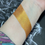 Thumbnail: Swatched gold eyeshadow on wrist; shimmering color for makeup application.