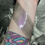 Thumbnail: Swatches of shimmer eye shadow on wrist with tattoo background.