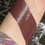 Thumbnail: Swatched dark burgundy lipstick on a wrist, beauty product test.