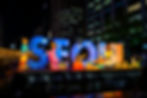 Illuminated figures in traditional attire and Seoul sign at night festival. Bright colors, city backdrop. Visible text: "Your Seoul, Lights your dre."