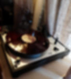 Turntable playing a vinyl record, with a stylus engaged and soft lighting creating a warm, nostalgic atmosphere.