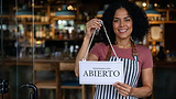 freepik_photo-a-25yearold-hispanic-woman-with-curly-black-hair-wearing-an-apron-holds-a-si