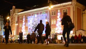 depositphotos_60716133-shopping-center-in-city-exterior-walking-people-night-christmas-tree-and-christmas-lights