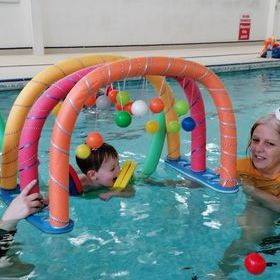 Patient swimming teacher offering reassurance and progressive skill development during SEN swimming lesson