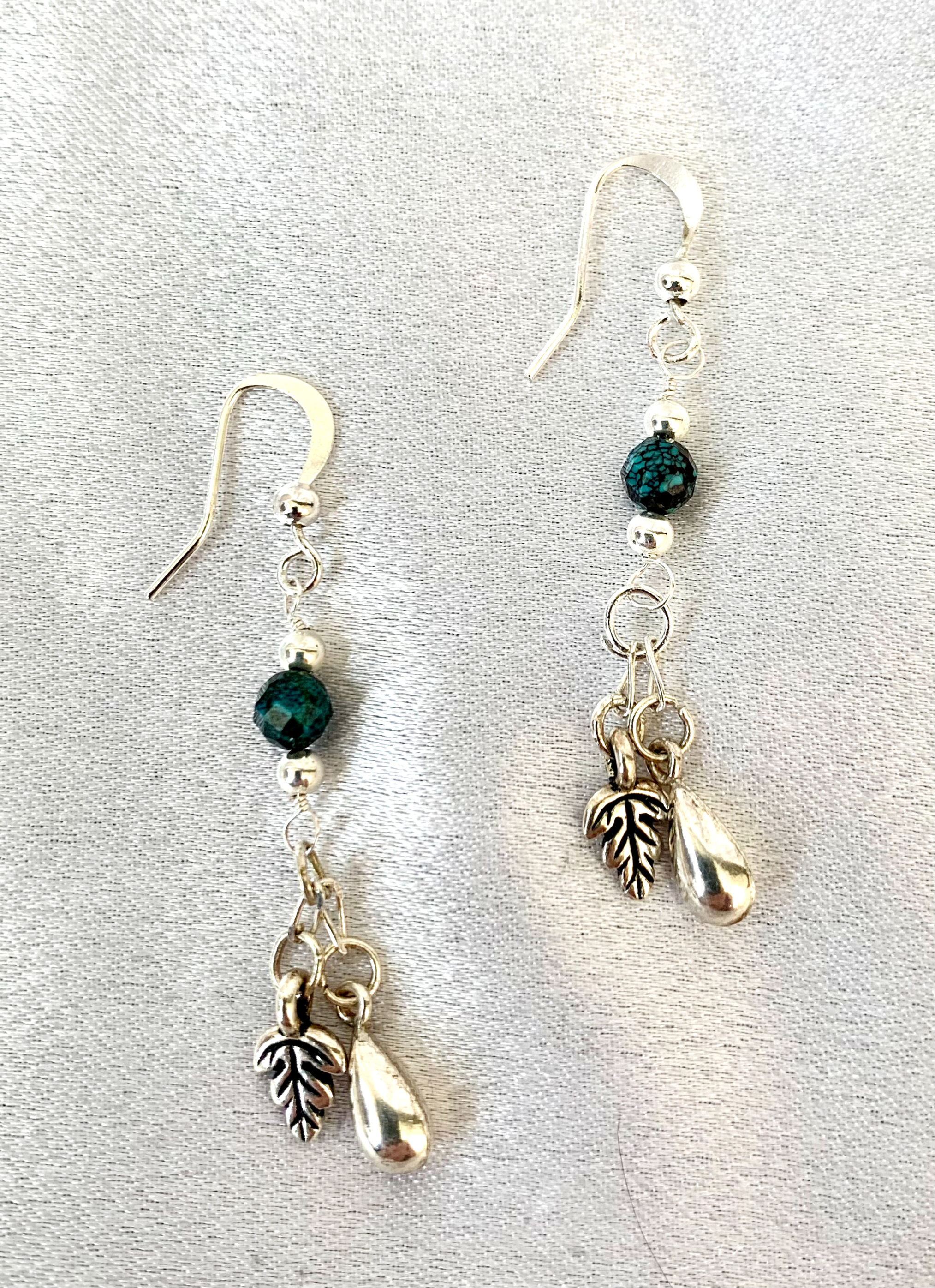 These handmade gemstone earrings include a small faceted African Turquoise with silver plated leaf & teardrop charms.