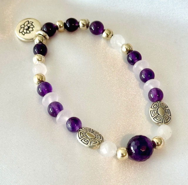 This handmade gemstone bracelet includes a loop of Amethyst, Rose Quartz , a dangling Lotus, pewter & silver plated beads.