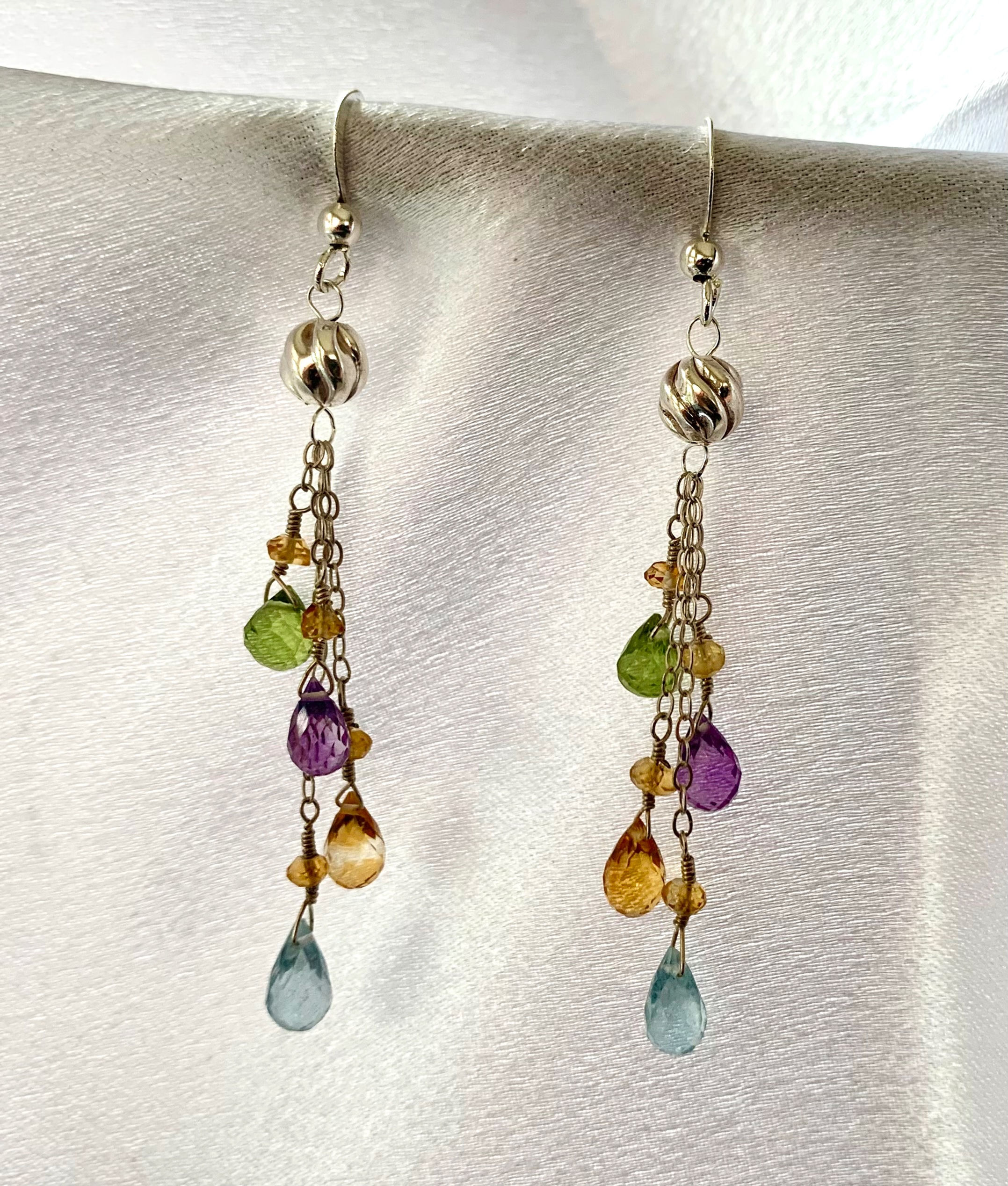 These handmade gemstone earrings include 4 dangles of Aquamarine, Amber, Amethyst & Peridot on gold plated links.