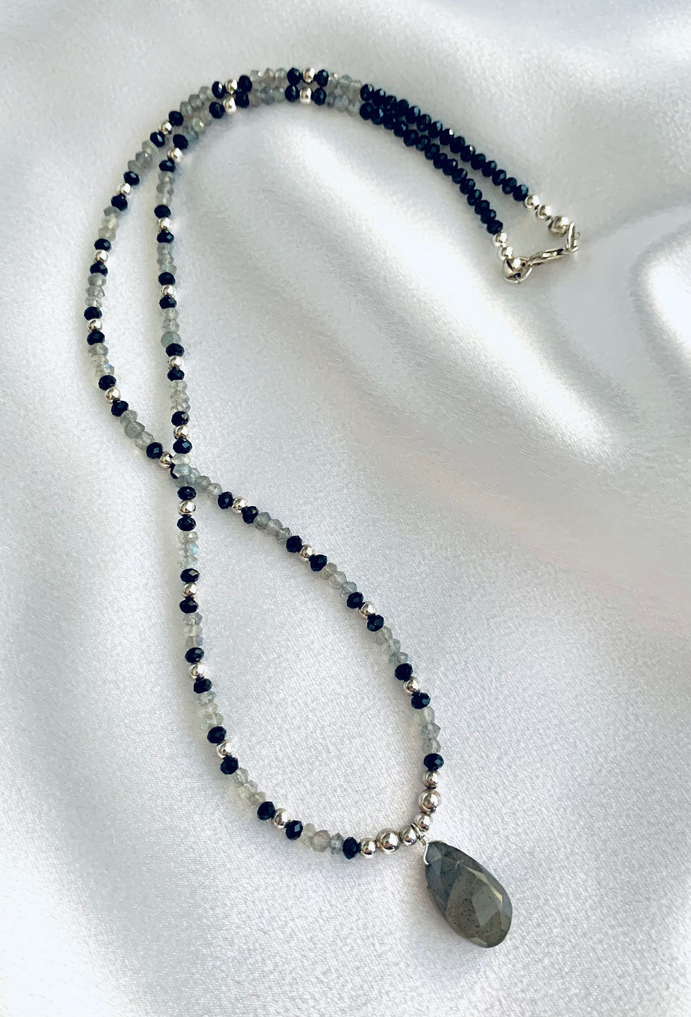 Thumbnail: This handmade gemstone necklace includes a Labradorite briolette dangling from Labradorite, Black Onyx & silver plated beads.
