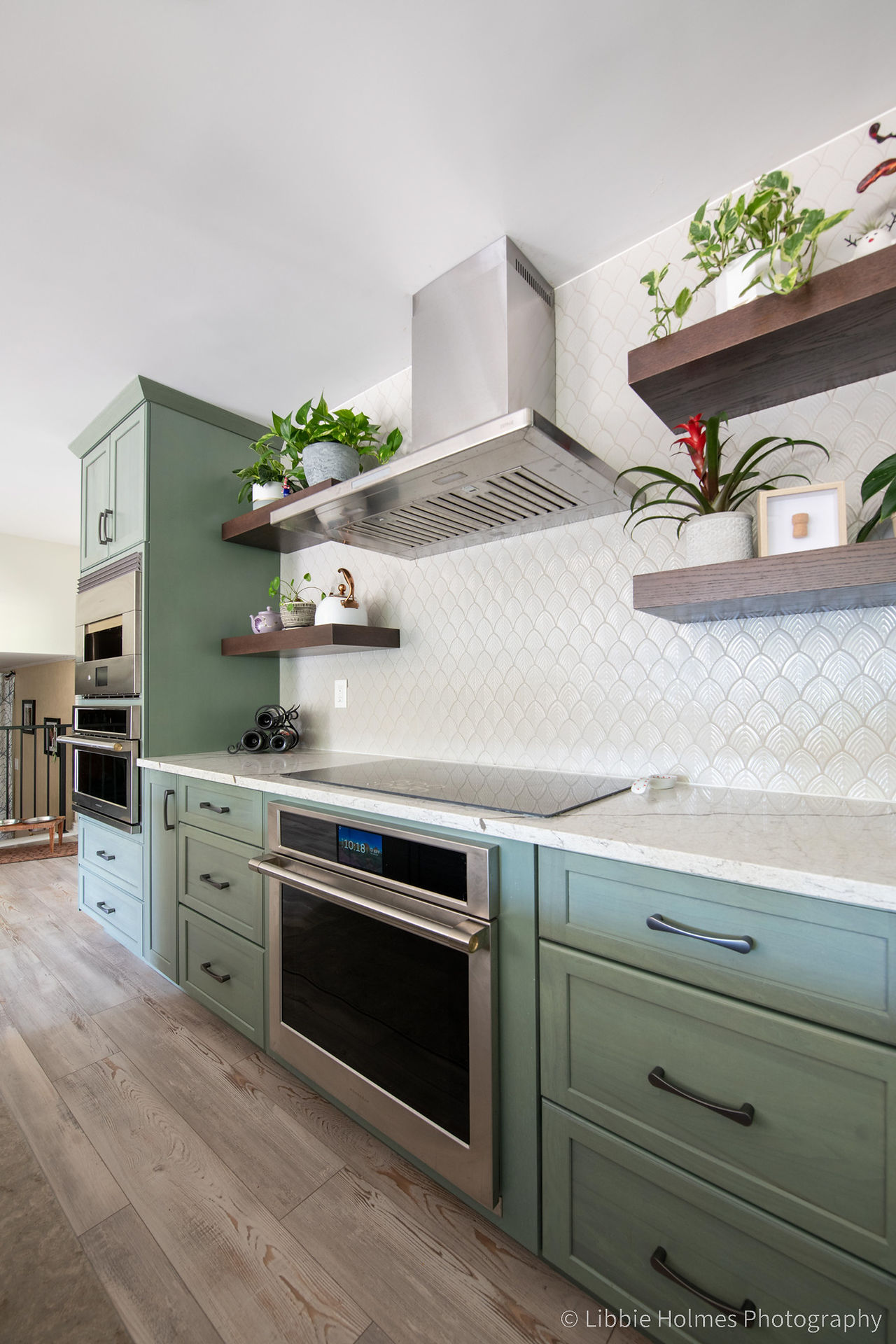 Newly remodeled kitchen with green cabinets,, wood floors and monogram appliances