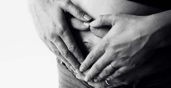 Dvě ruce tvoří srdce na břiše. Ukázka těhotenství, těhotenské , láska, černobílé.