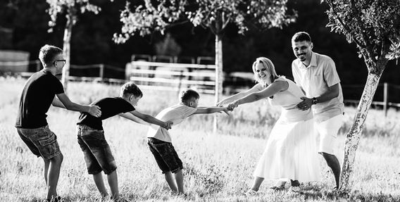 Rodina hraje přetahovanou na louce, slunečný den, úsměvy, zábava, Rodinné foto.