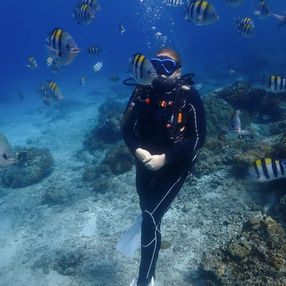 A woman scuba diving at Green Island, Taiwan, surrounded by butterfly fish