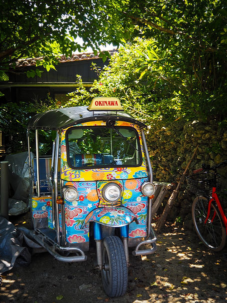 Colourful tuk-tuk parked in front of a building in Okinawa, Japan