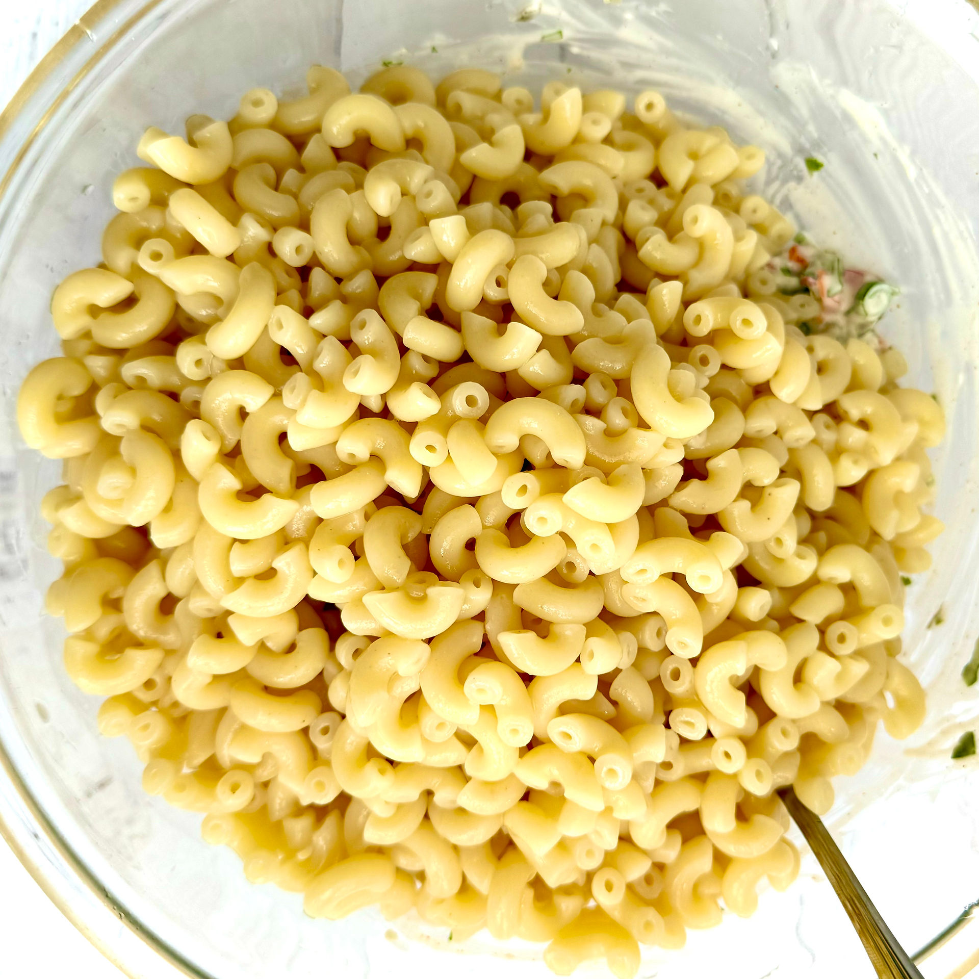 adding macaroni to dressing