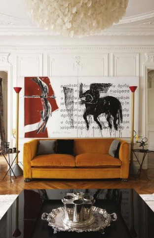 Large white, red, and black painting over orange couch in renovated sitting area