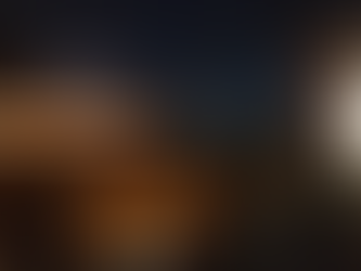 Movimento noturno em mesas de bar em uma calçada urbana.