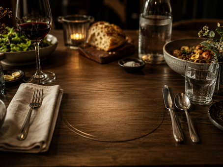 Uma mesa posta de forma elegante, porém com um espaço vazio no centro onde deveria estar o prato principal. Ao redor, talheres, guardanapos e elementos da refeição permanecem intactos. A luz deve destacar a ausência, criando uma atmosfera contemplativa e simbólica sobre desejo, expectativa e aquilo que falta.