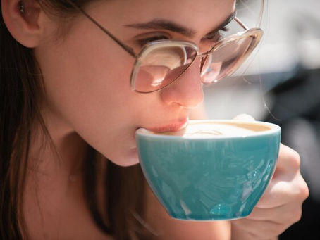 Um close em câmera lenta de uma taça ou xícara no instante em que toca os lábios de alguém.