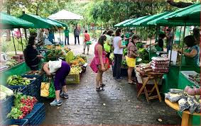 Feira ao ar livre em uma cidade fronteiriça, com bancas de especiarias e pessoas trocando produtos.