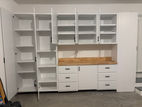 White storage cabinets with open shelves and drawers in a garage setting.