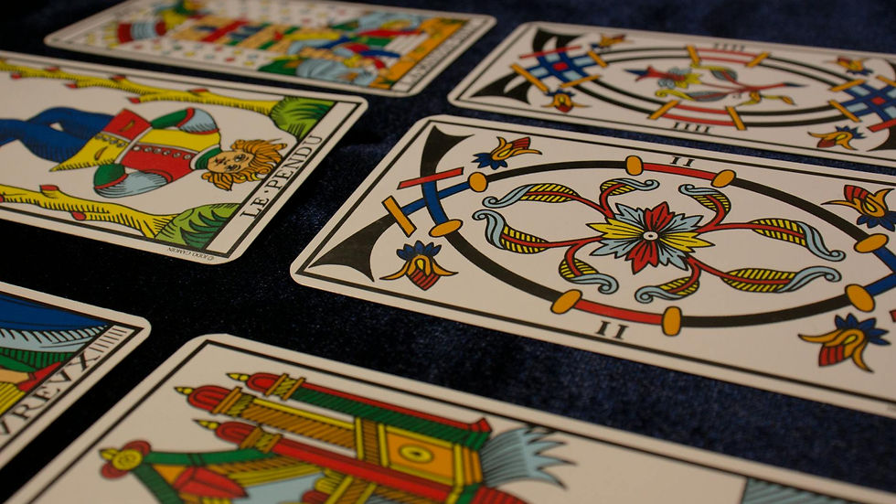 Close-up view of beautifully illustrated tarot cards arranged on a dark surface.