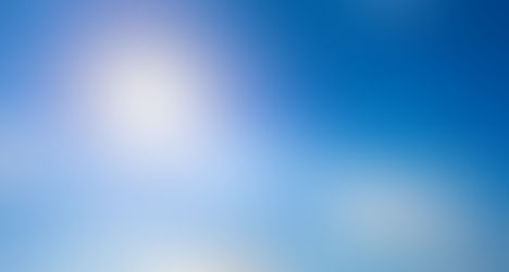 Céu azul com poucas nuvens e o sol brilhando.