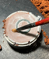 wax mold submerged half way into sand for sand casting