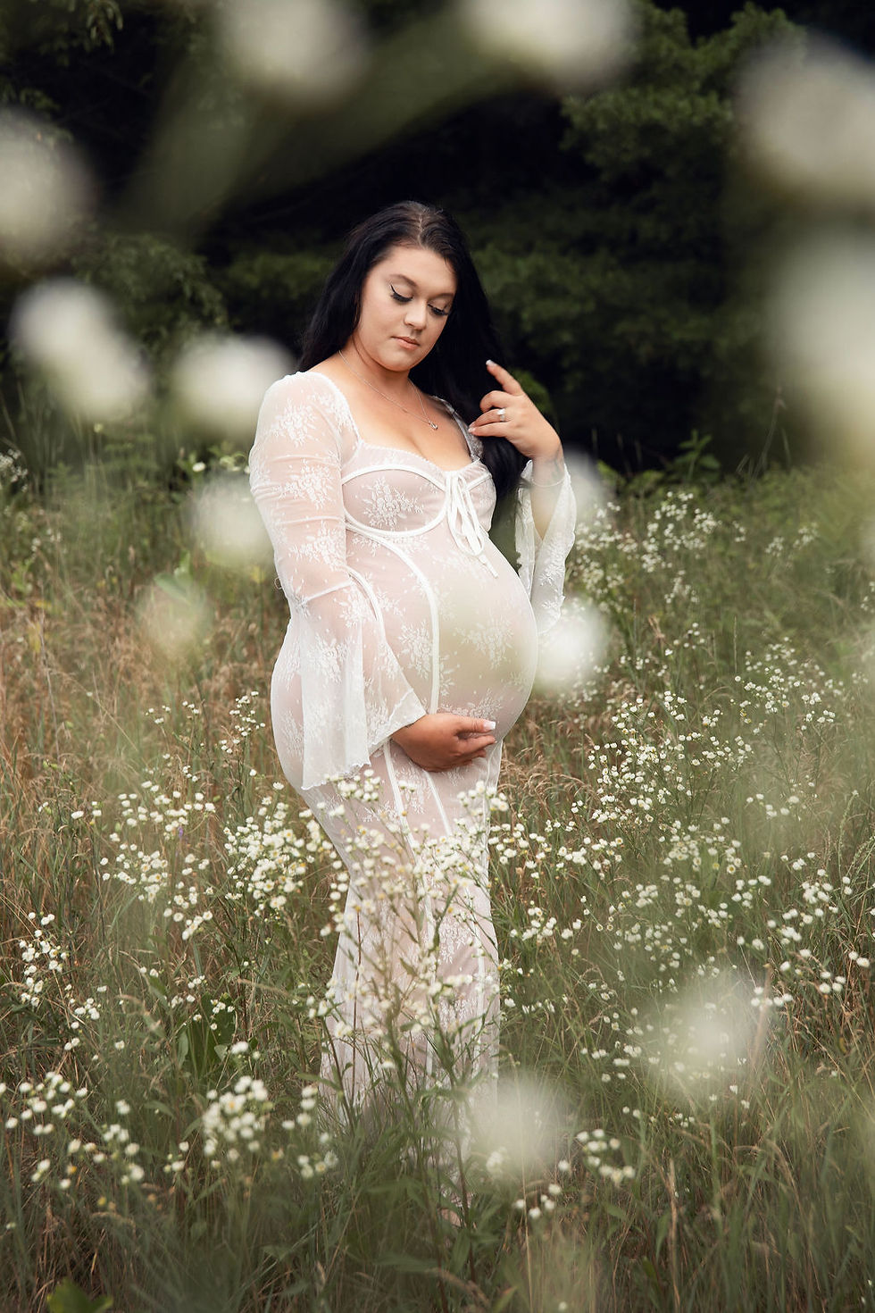 Maternity session, woman in a white dress in a white flower field.