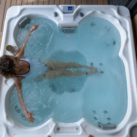 woman lounging in hot tub in backyard