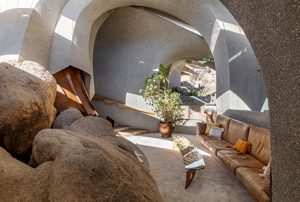 Modern desert house interior with rock formations and curved walls