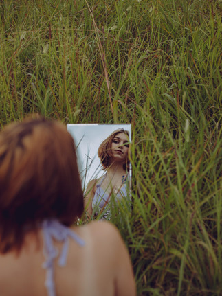 creative portrait with reflection in a mirror in a field