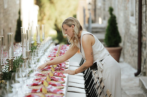 Weddingstylist van LIVA studio tijdens de opbouw en styling van een lange bruiloftstafel.
