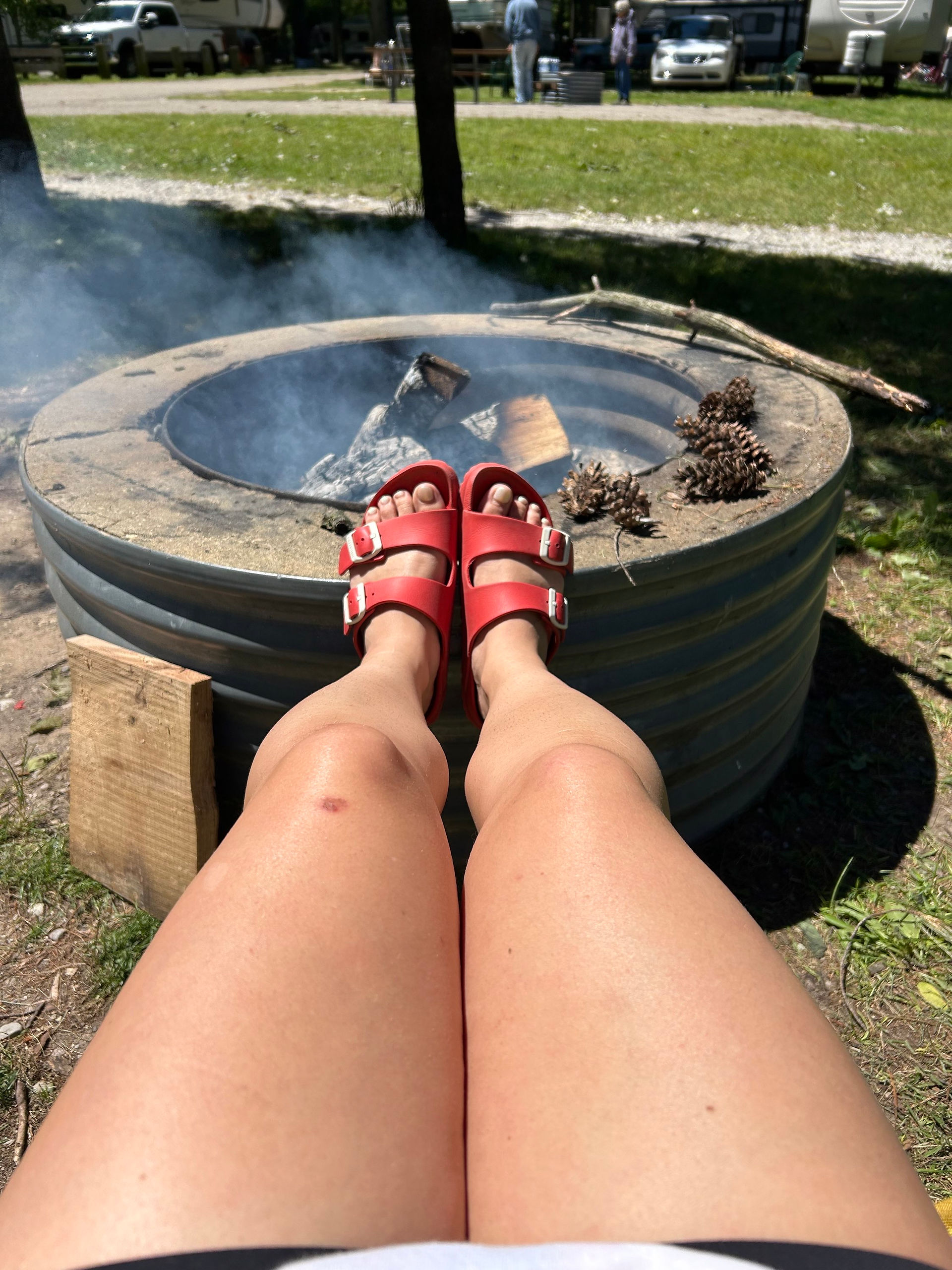 camping with feet up by fire