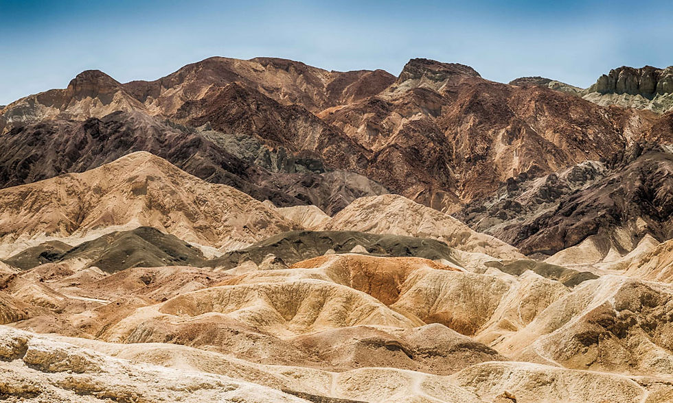 Undulating mountain range with various colors on each elevation from gold, orange, brown, gray and black. ©AlonzoWright