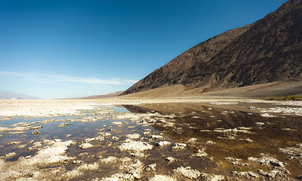 Badwater Basin's burnt landscape with chunks of crusty crystals poking out of the water. ©AlonzoWright