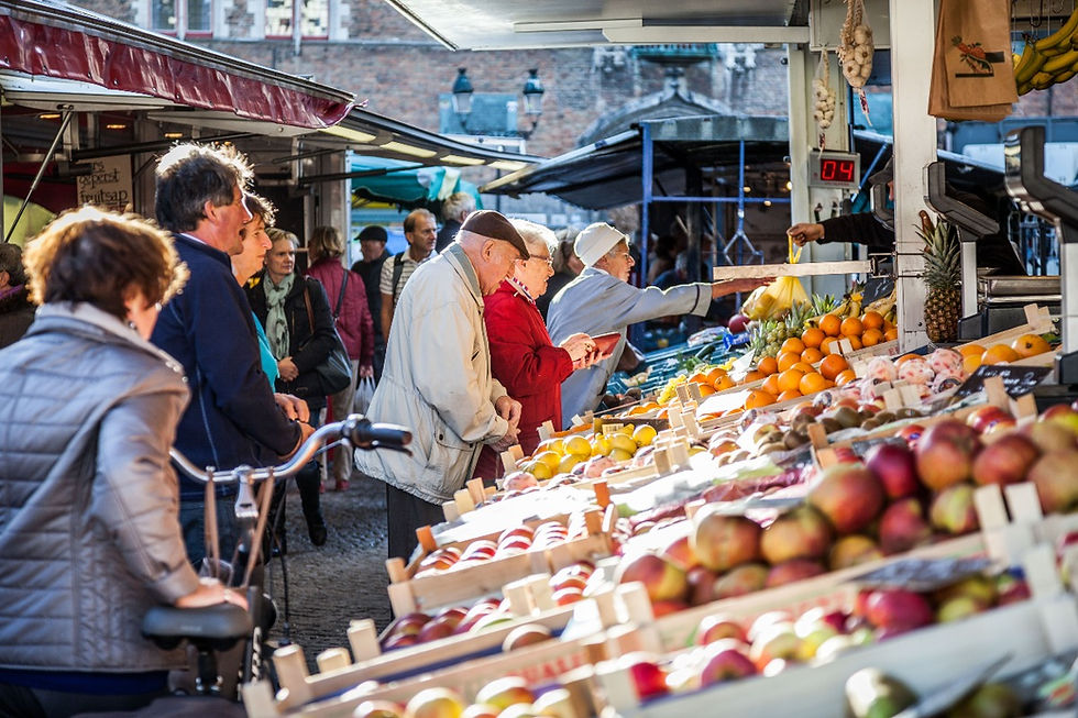 People scouring through produce in a traditional food market is one example of foodie travel. ©AlonzoWright for Manifesting Travel