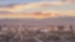 the Las Vegas Strip at dusk with a soft pastel sunset and mountains in the background and Las Vegas resorts in the forefront.