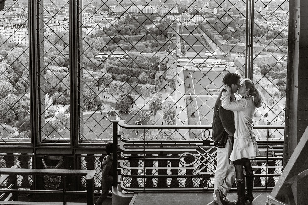 Save money on travel by saving what you'd spend on your weekly coffee habit on a ticket to the top of the Eiffel Tower, like this loving couple kissing with the city of Paris and iron Tour Eiffel as their backdrop. ©AlonzoWright