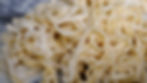 Christmas Fettuccine from The Holiday. Close-up of creamy fettuccine pasta with a white sauce. The noodles are tangled, and the background is blurred, enhancing focus.