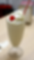 Milkshake in a glass topped with whipped cream, cherry, and red-striped straw on a wooden table. Light and playful mood. Inspired by the $5 milkshake from Pulp Fiction.