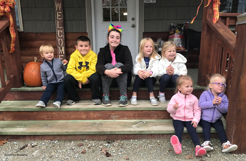 Image of 6 toddlers sitting on steps with a teen girl. Raleigh Psychotherapy, counseling, loneliness, Katherine Broadway