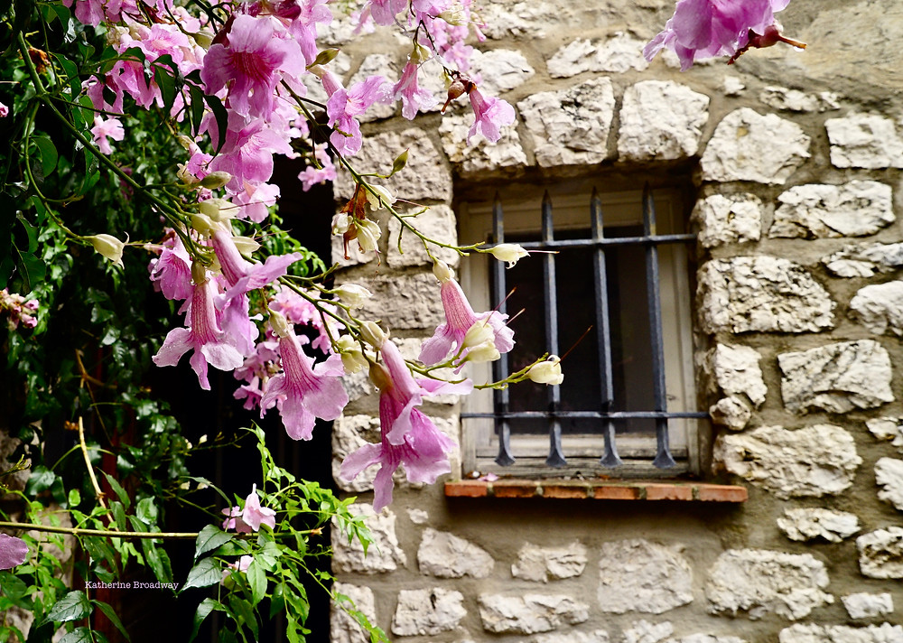 Image of old stone jailhouse with purple flowers in foreground. Raleigh Psychotherapy, counseling, happiness, Katherine Broadway