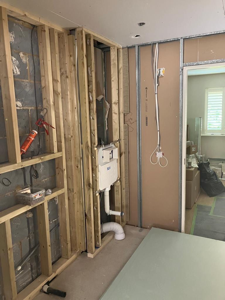 Home improvement services showing wall framing and plumbing.