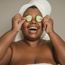 Person in towel at spa with cucumbers over their eyes