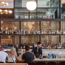 Photo of people sitting at a bar and a bartender serving and link to The Core
