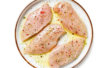 Raw meat in the marinade.Marinated Chicken Breasts with spices . isolated on white backgro