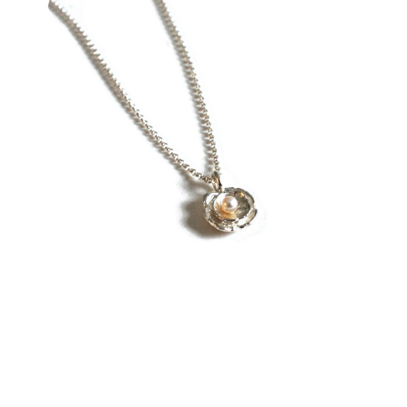 Pendentif ornée d'une perle en forme de fleur de coquillage