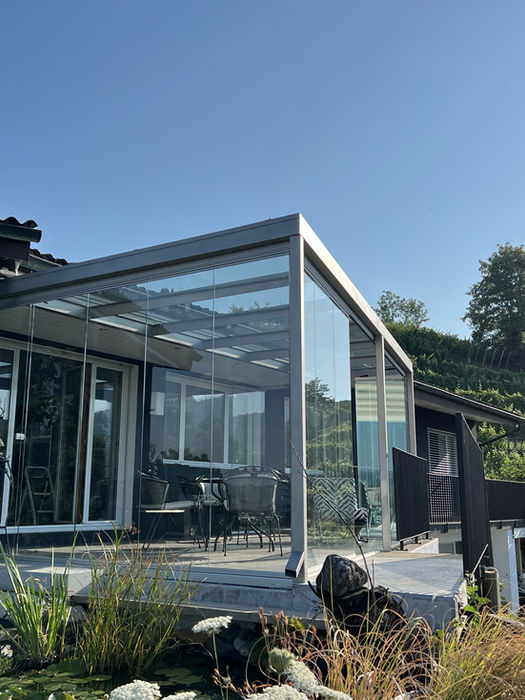 Sitzplatzüberdachung aus CNS in Egliswil, Aargau – Geniessen Sie mehr Komfort und Schutz mit einer hochwertigen Sitzplatzüberdachung aus glasperlengestrahltem Chrom-Nickel-Stahl. Unsere trapezförmige Sitzplatzverglasung und COVER Balkonverglasung sind eine elegante und funktionale Lösung, um den Aussenbereich zu erweitern. Durch ein robustes Geländer und die flexible Schiebe-Drehverglasungen wurde die neue Terrasse perfekt. Optimieren auch Sie Ihren Aussenbereich mit modernen Verglasungssystemen, die Schutz vor Wind und Wetter bieten und gleichzeitig ästhetisch ansprechend sind.